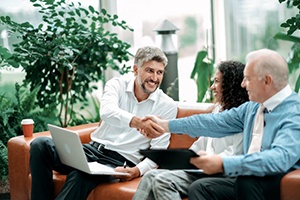 a man shaking hands with others and smiling