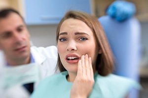 Woman holding cheek in pain