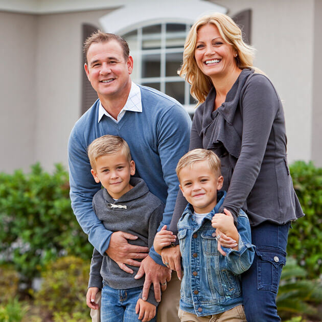 Happy family of four smiling together outdoors