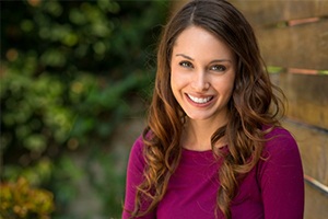 A woman smiling outside.