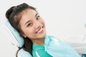 Female dental patient smiling and sitting in chair