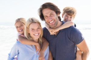 family of four smiling and embracing