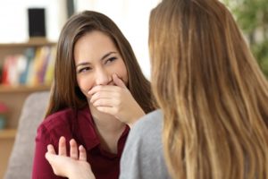 person talking and covering their mouth