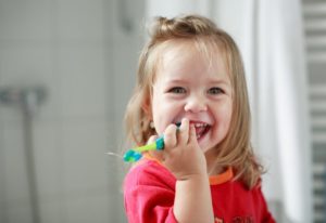 little girl holding toothbrush