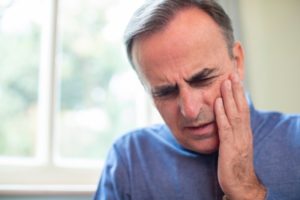 Man with hand on face wonders if it's a dental emergency