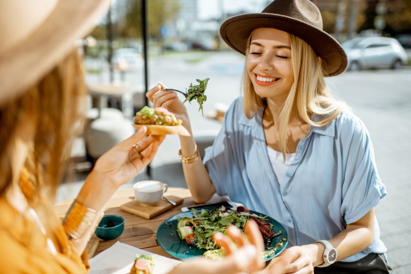 Woman smiling while eating lunch with friend