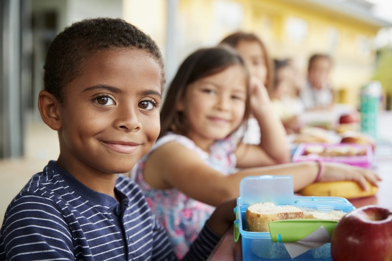 Kids smiling while eating lunch together