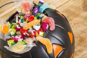 black plastic pumpkin filled with Halloween candy