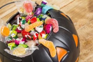 black plastic pumpkin filled with Halloween candy 