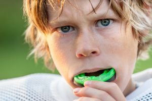 Young boy inserting mouthguard