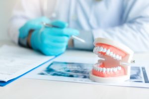 a dentist in front of a pair of dentures