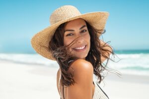 Woman wearing a hat to protect her lips at the beach
