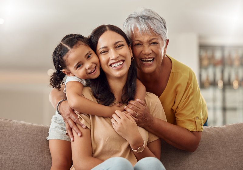 Grandmother, mother, and child smiling with good dental health