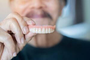 man holding an upper denture